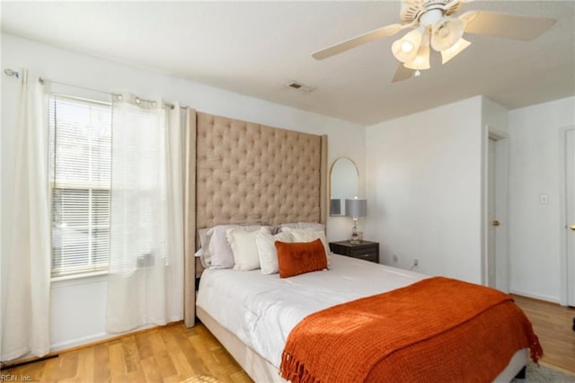 bedroom featuring multiple windows, light wood-type flooring, and ceiling fan