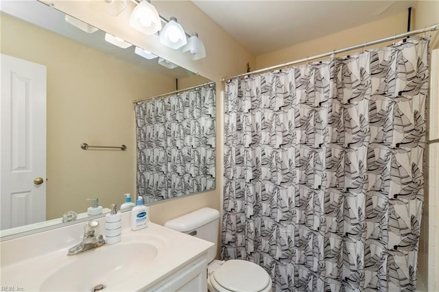 bathroom with vanity, toilet, and curtained shower