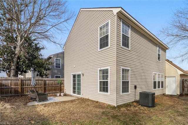 rear view of house with a lawn, central AC unit, and a patio area