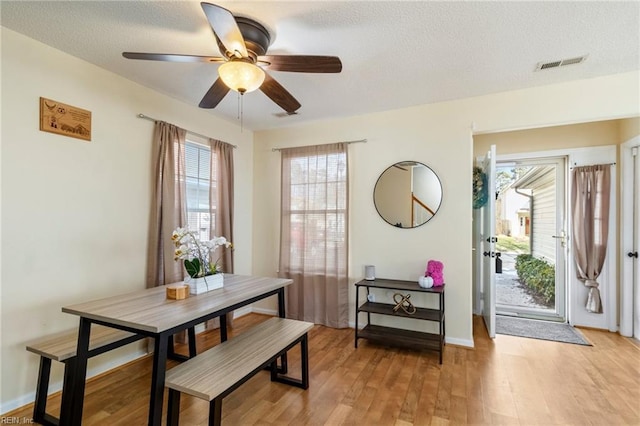 dining room featuring ceiling fan, a textured ceiling, and light wood-type flooring