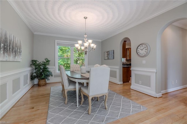 dining room with ornamental molding, a chandelier, and light hardwood / wood-style floors