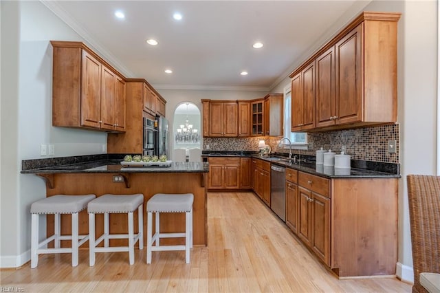 kitchen featuring sink, crown molding, light hardwood / wood-style floors, and dishwasher