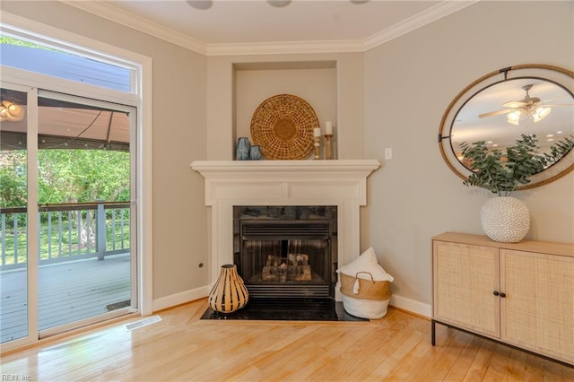 living area with wood-type flooring and crown molding