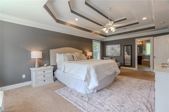 bedroom with connected bathroom, ceiling fan, and a tray ceiling