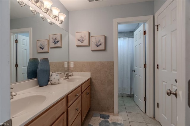 bathroom featuring vanity, a chandelier, tile patterned flooring, and tile walls