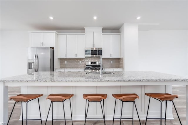 kitchen featuring a spacious island, stainless steel appliances, and white cabinets