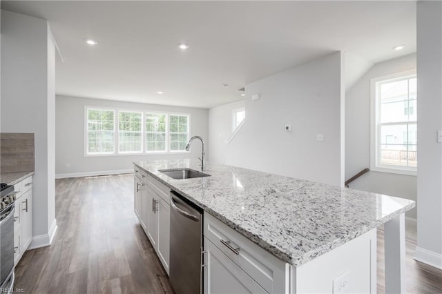 kitchen with white cabinetry, sink, a kitchen island with sink, stainless steel appliances, and light stone countertops