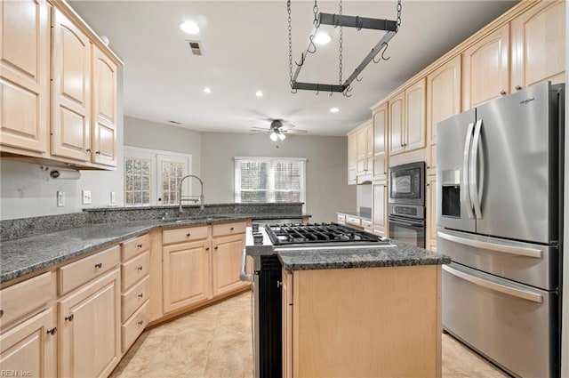 kitchen featuring stainless steel appliances, a kitchen island, and light brown cabinets