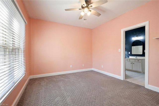 carpeted spare room with sink and ceiling fan