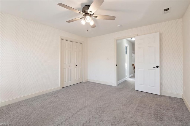 unfurnished bedroom with light carpet, ceiling fan, and a closet