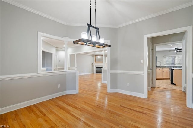 unfurnished dining area with crown molding, ceiling fan, and light wood-type flooring