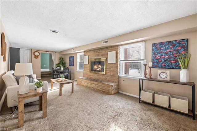 living room featuring a brick fireplace and a textured ceiling