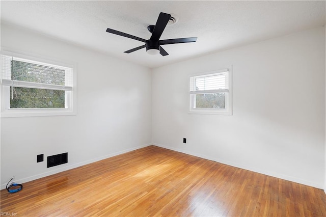 empty room with ceiling fan and hardwood / wood-style floors