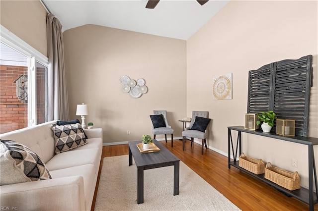 living room with lofted ceiling, hardwood / wood-style floors, and ceiling fan