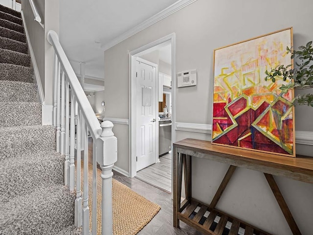 staircase featuring crown molding and wood-type flooring