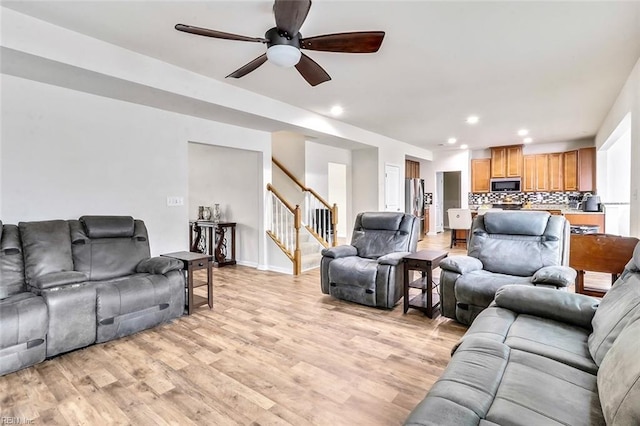 living room with ceiling fan and light wood-type flooring