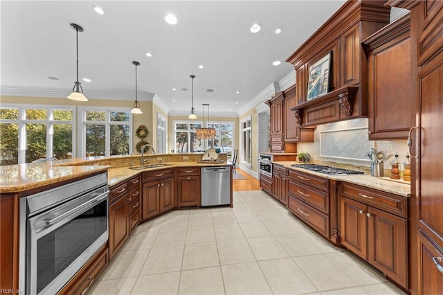 kitchen featuring crown molding, stainless steel appliances, sink, and hanging light fixtures