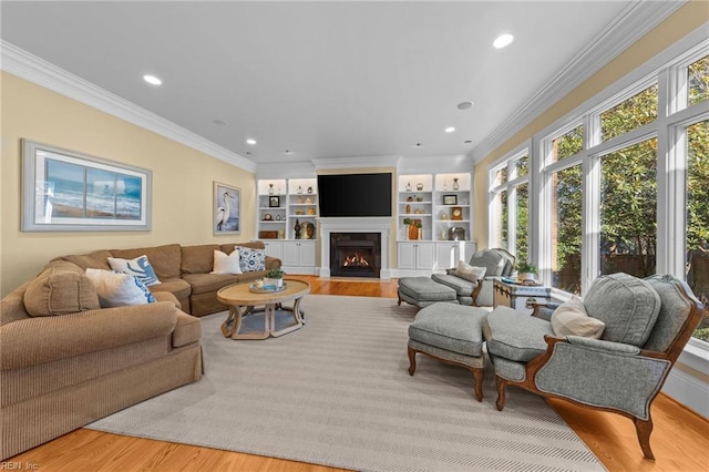 living room featuring crown molding, built in shelves, and light hardwood / wood-style floors