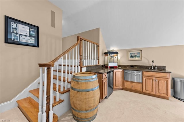 interior space featuring dark stone counters, sink, vaulted ceiling, and light carpet