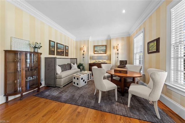 dining room featuring ornamental molding, wood-type flooring, and a healthy amount of sunlight