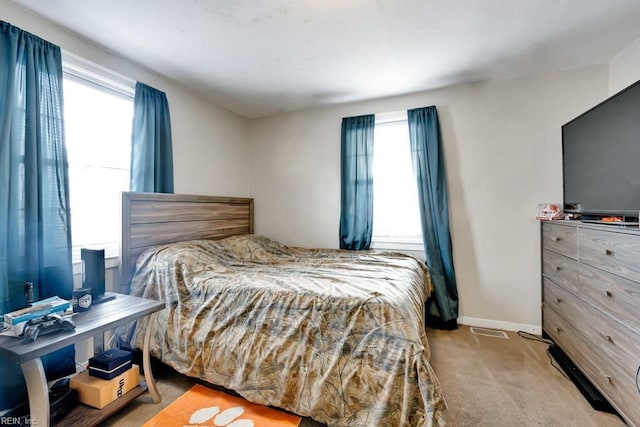 carpeted bedroom with multiple windows