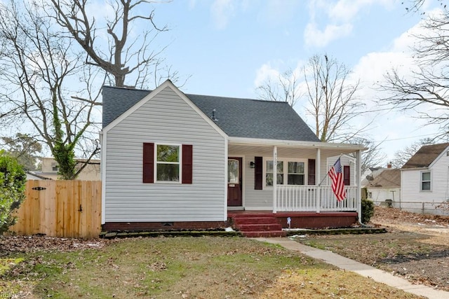 bungalow-style house featuring covered porch and a front lawn