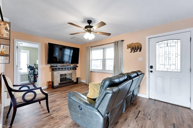 living room featuring ceiling fan, hardwood / wood-style floors, and a fireplace