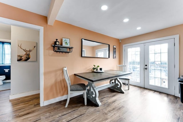 dining space with french doors, wood-type flooring, beam ceiling, and a wealth of natural light