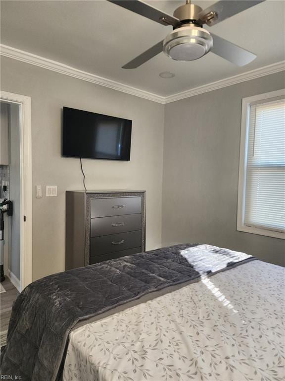 bedroom with crown molding, ceiling fan, and hardwood / wood-style floors