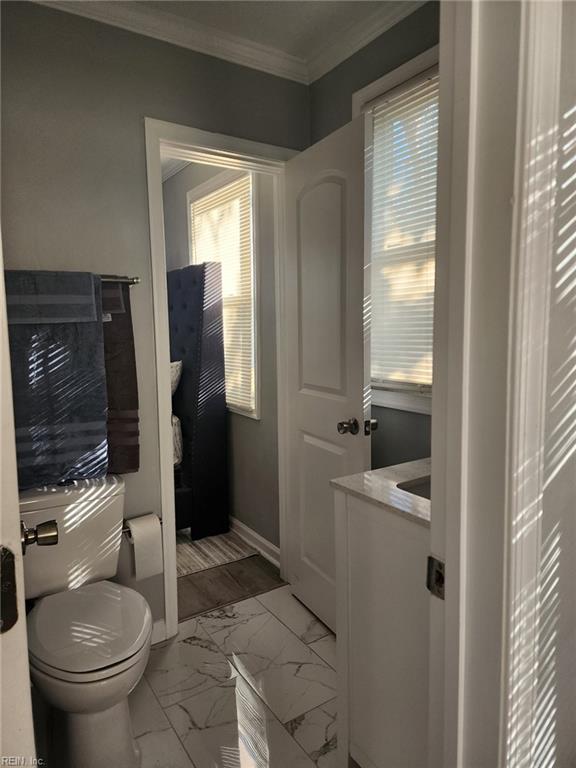 bathroom with crown molding and toilet