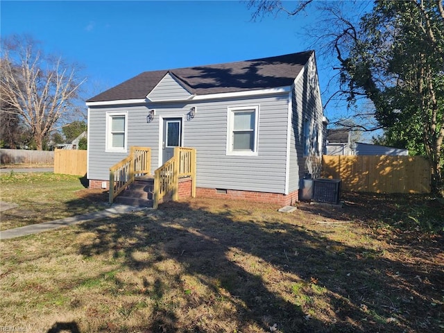 view of front of home with central AC unit and a front lawn