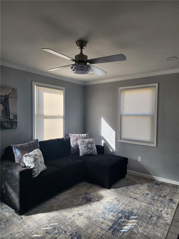 living room with ornamental molding and ceiling fan