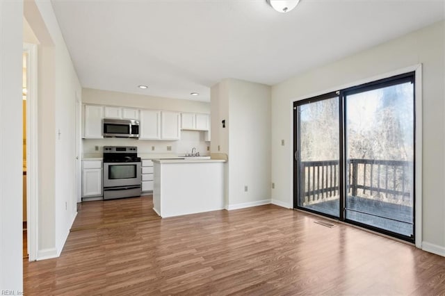 kitchen featuring white cabinetry, appliances with stainless steel finishes, and hardwood / wood-style floors