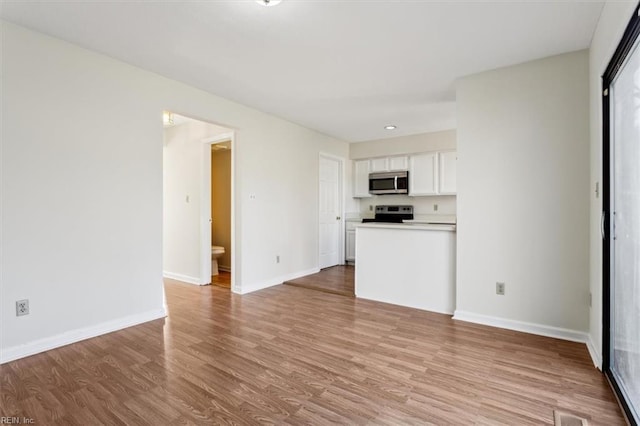 kitchen featuring white cabinetry, electric range oven, and light hardwood / wood-style floors