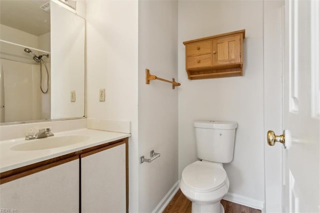 bathroom with vanity, hardwood / wood-style flooring, toilet, and walk in shower