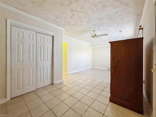 tiled empty room featuring crown molding, ceiling fan, and a textured ceiling