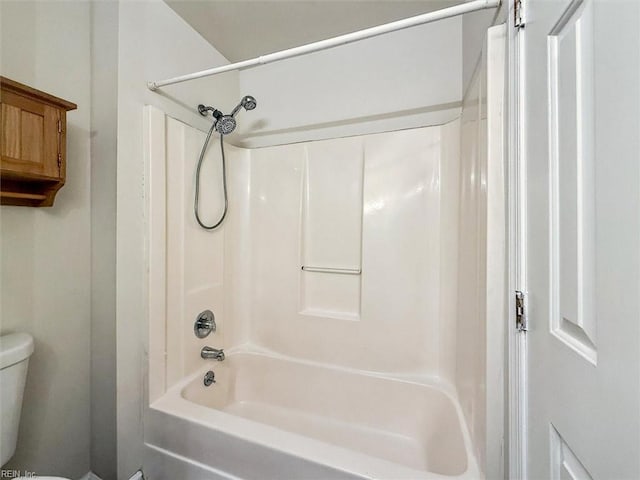 bathroom featuring washtub / shower combination and toilet