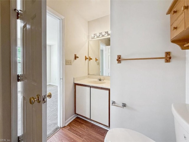 bathroom featuring hardwood / wood-style flooring, vanity, and toilet