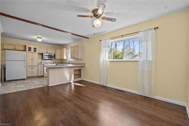 kitchen featuring a breakfast bar, sink, light wood-type flooring, kitchen peninsula, and white appliances