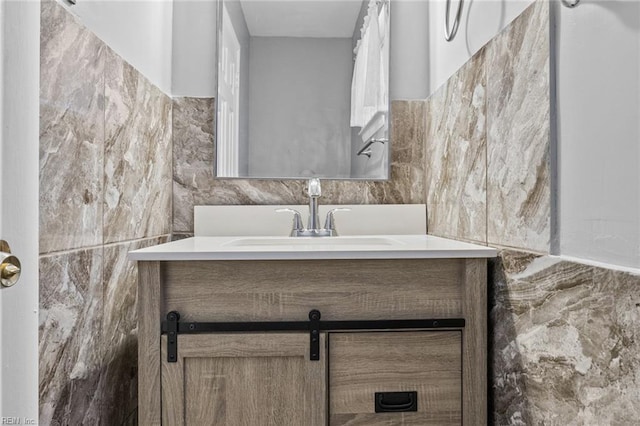 bathroom featuring vanity and tile walls