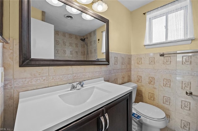 bathroom with vanity, tile walls, and toilet