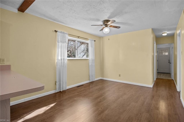 empty room featuring hardwood / wood-style flooring, ceiling fan, and a textured ceiling