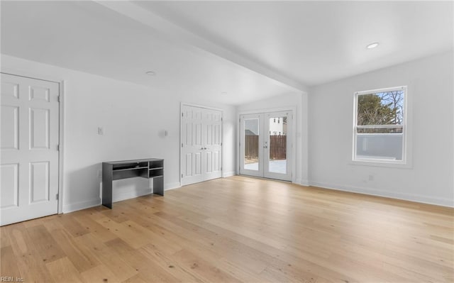 unfurnished living room featuring vaulted ceiling with beams, light hardwood / wood-style flooring, and french doors