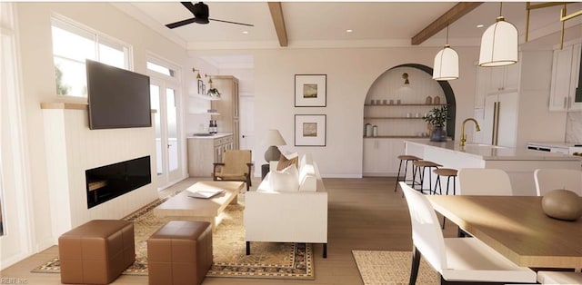 living room featuring ceiling fan, beam ceiling, sink, and light wood-type flooring