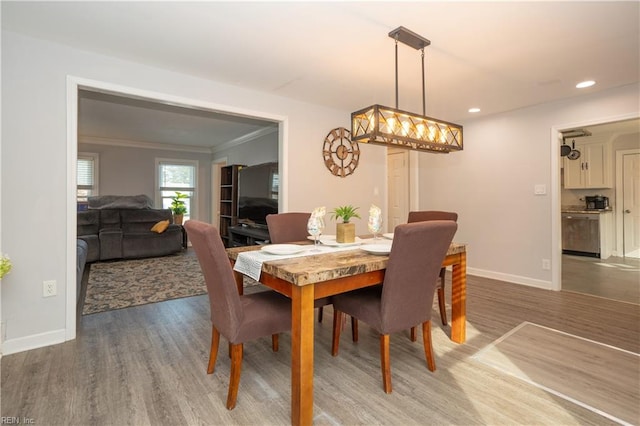 dining area with hardwood / wood-style flooring and crown molding