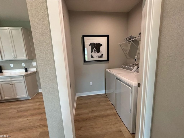 laundry room with washer and dryer and light wood-type flooring