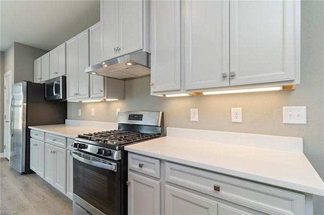 kitchen with appliances with stainless steel finishes, light wood-type flooring, and white cabinets