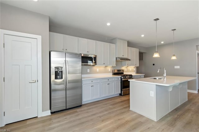 kitchen featuring white cabinetry, stainless steel appliances, decorative light fixtures, and sink