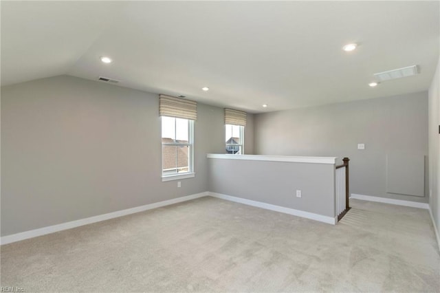 carpeted empty room featuring lofted ceiling