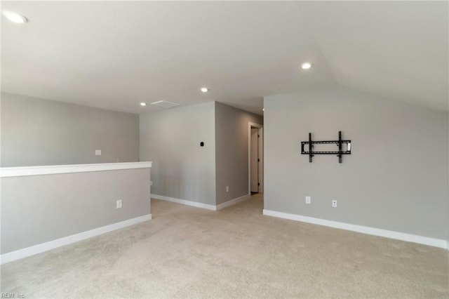 carpeted spare room with lofted ceiling